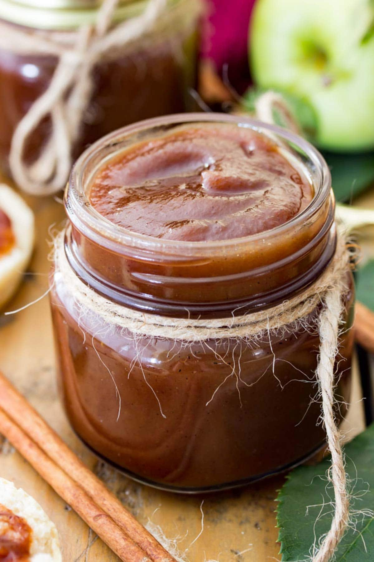 Rich brown apple butter recipe in a glass jar tied with twine