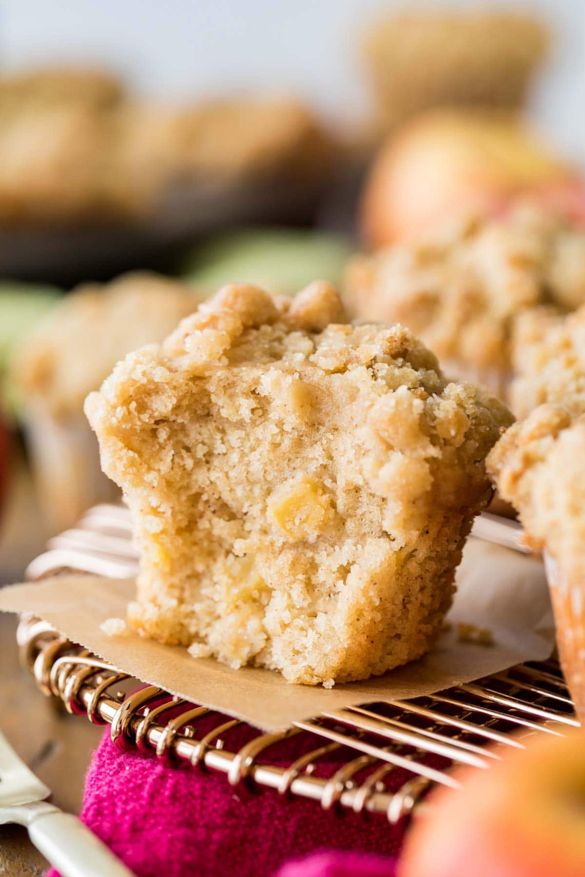 streusel topped muffin that's been cut in half to show bits of apple baked inside