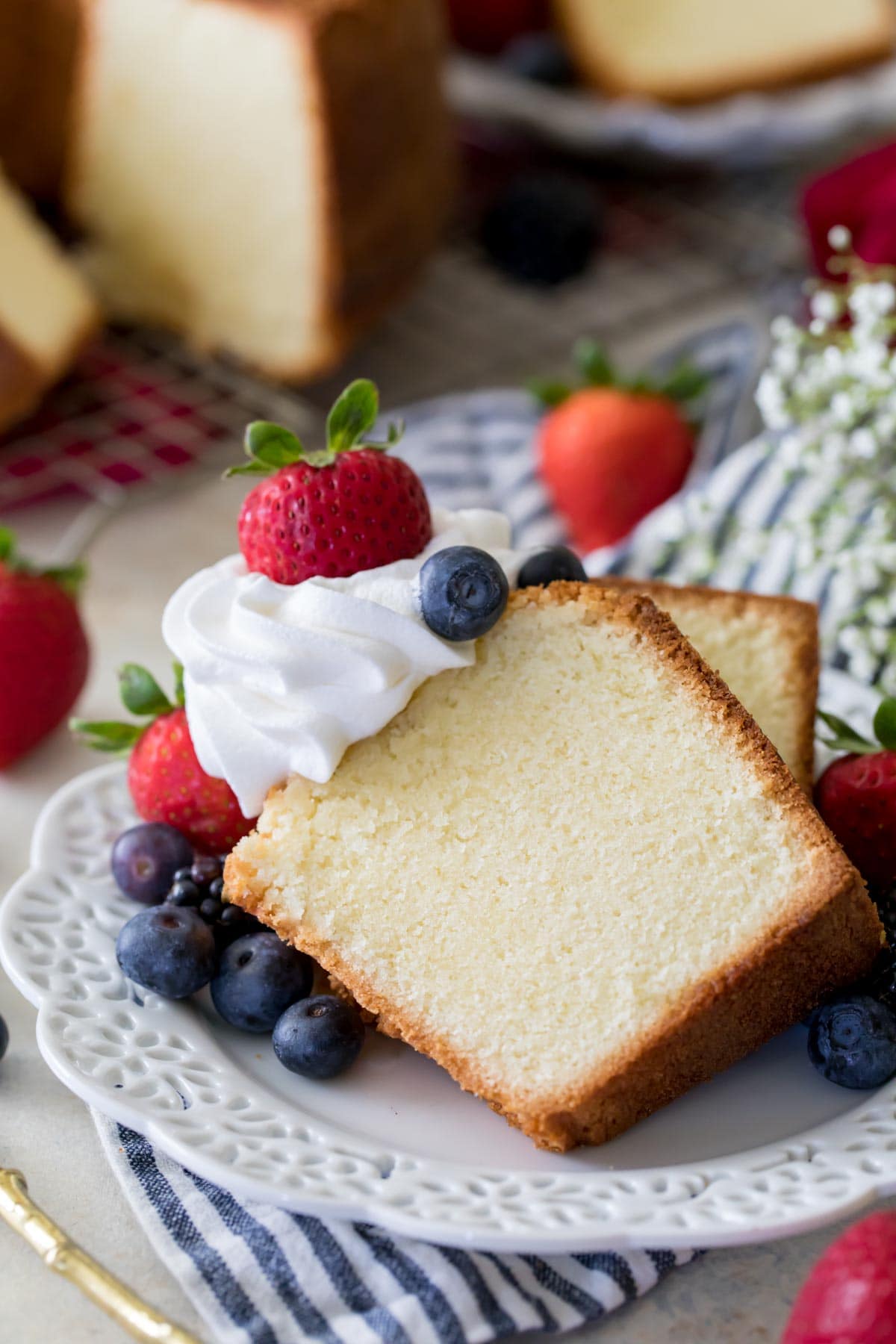 Two slices of pound cake topped with whipped cream and berries