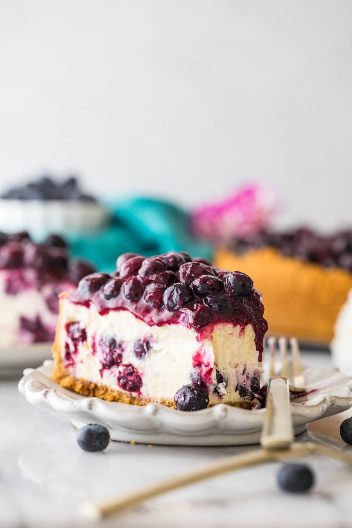 slice of cheesecake topped with blueberries missing one bite