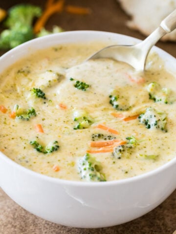 Bowl of broccoli cheddar soup with a spoon scooping out a bite.