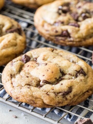 Brown butter chocolate chip cookies on a metal cooling rack.