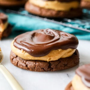 Buckeye cookie consisting of a chocolate cookie topped with peanut butter and chocolate.