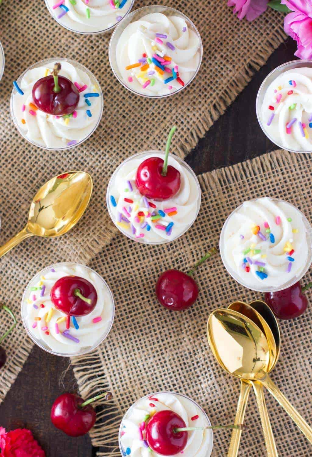 Overhead of cake batter dessert shooters topped with cherries