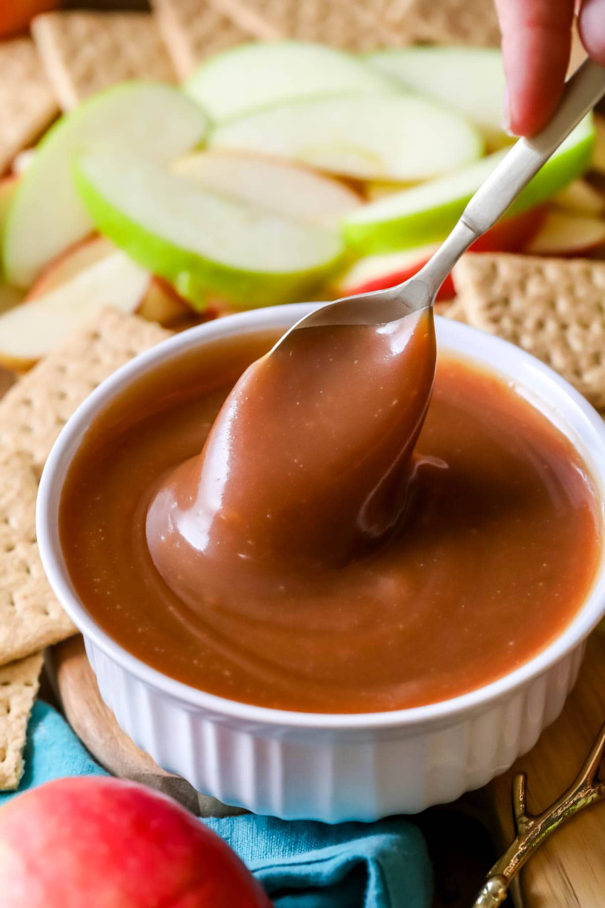 Dish of caramel apple dip being stirred with a spoon.