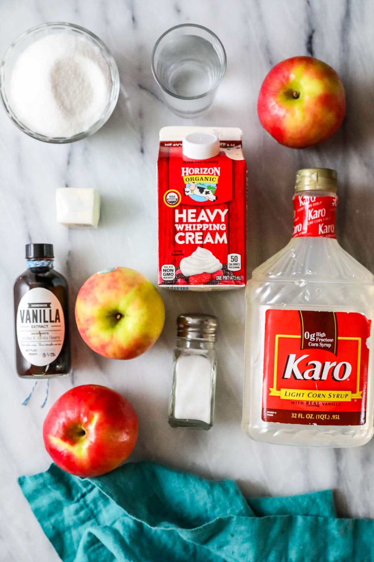 Overhead view of ingredients including corn syrup, sugar, heavy cream, apples, and more.