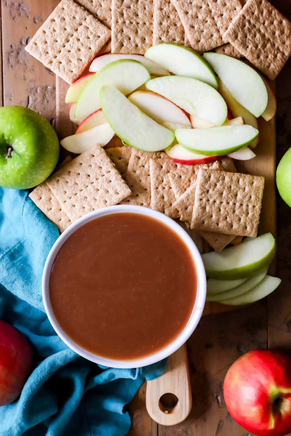 Overhead view of caramel dip, apple slices, and graham crackers.