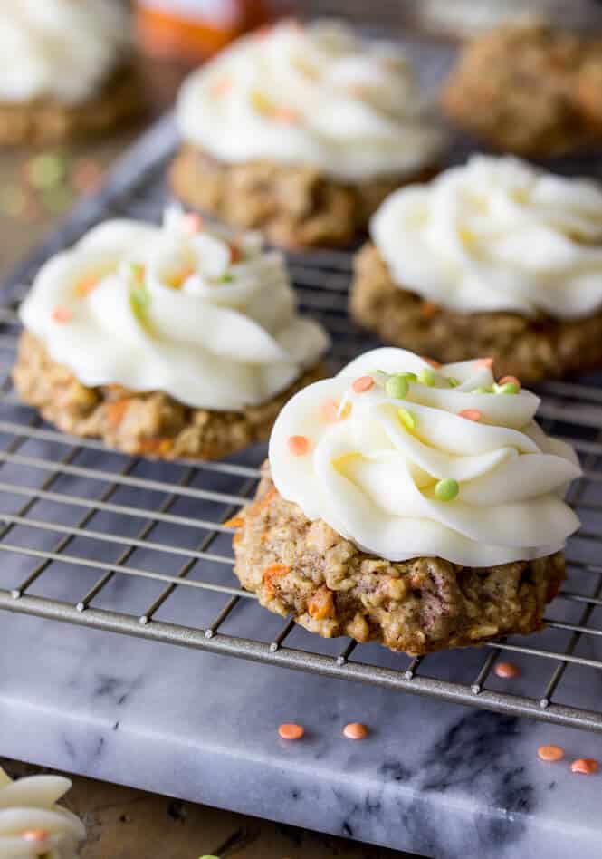 Carrot cake cookies on cooling rack, with icing and sprinkles
