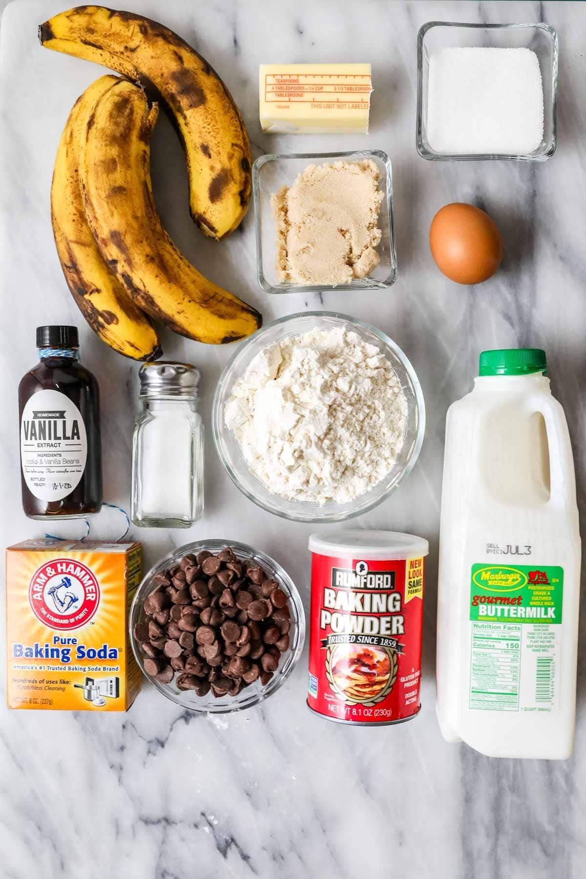 Overhead view of ingredients including bananas, buttermilk, chocolate chips, and more.