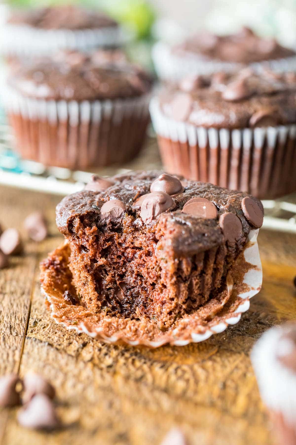 Chocolate muffin that's been unwrapped and is missing a bite.