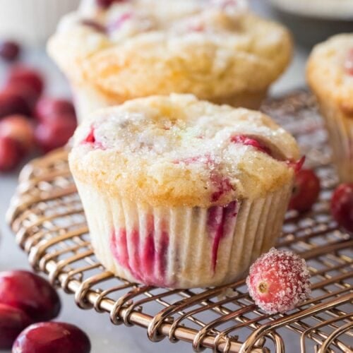 Cranberry muffins with sugared tops on a cooling rack.