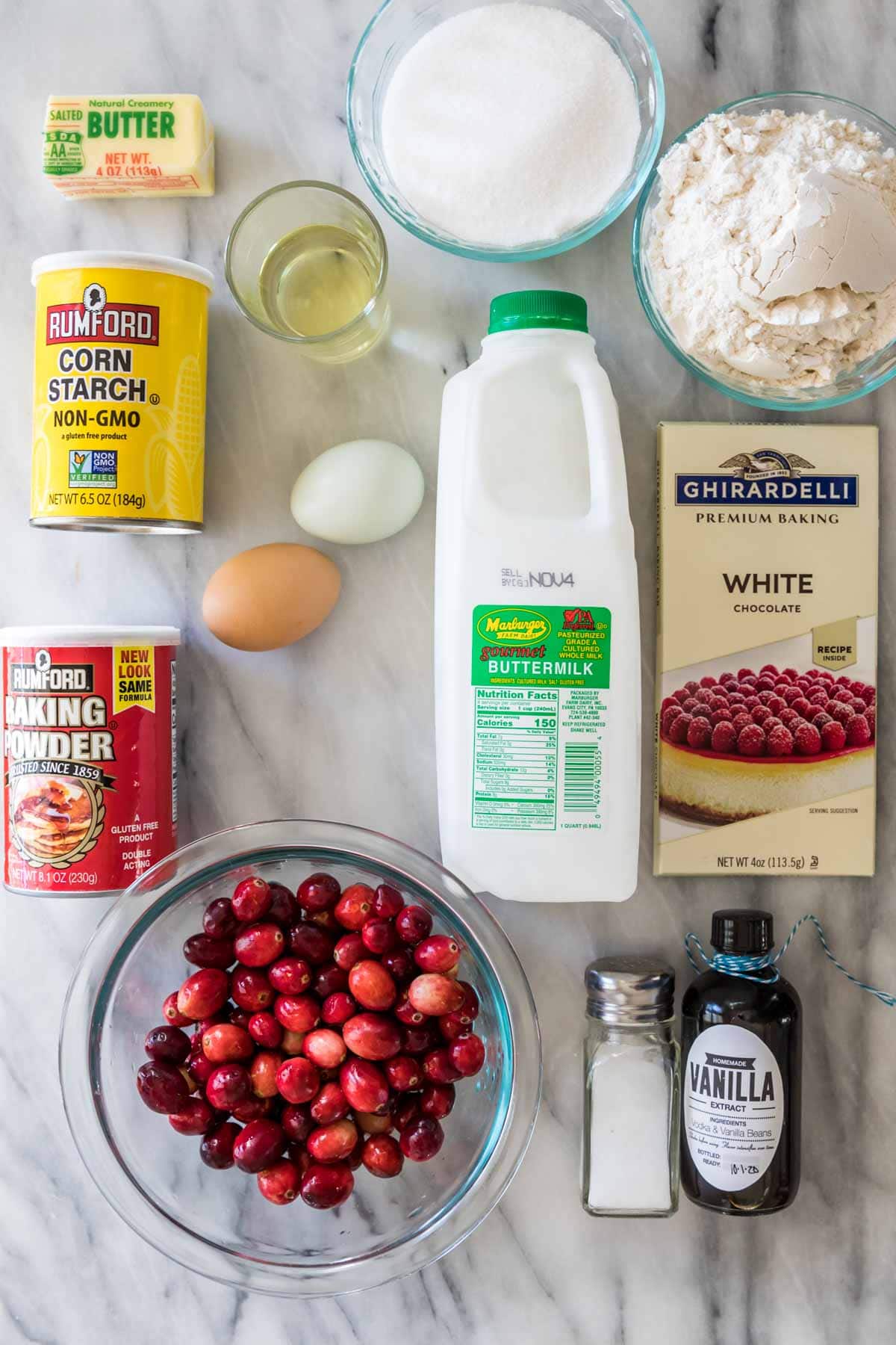 Overhead view of ingredients including buttermilk, white chocolate, cranberries, and more.