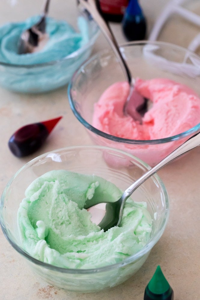 Dividing cream cheese mint batter and coloring three shades (pink, blue, and green)