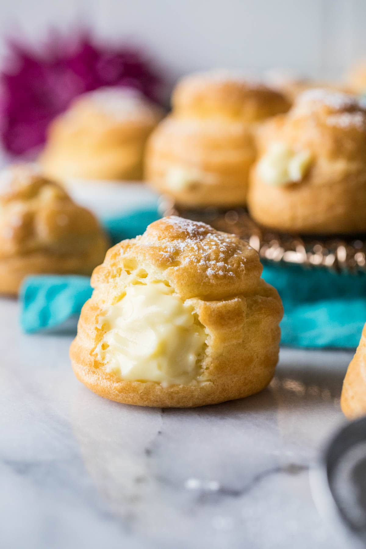 Round, custard-filled choux pastry topped with powdered sugar.