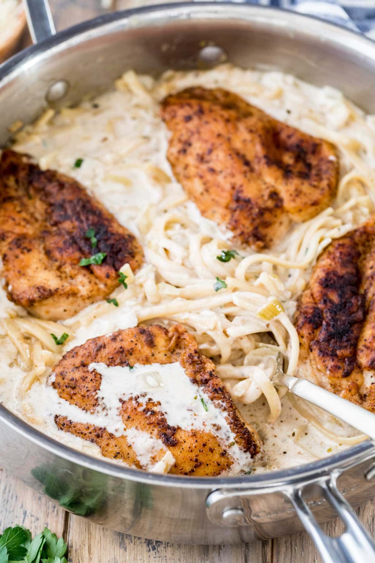 creamy chicken pasta dinner consisting of linguine pasta in a garlic cream sauce topped with seasoned chicken breasts