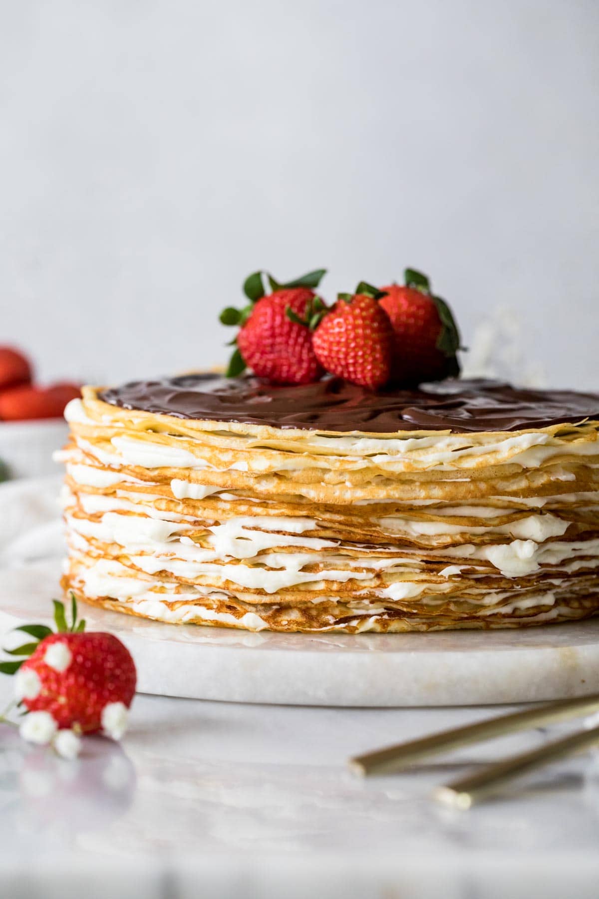 Crepe cake topped with chocolate ganache and fresh strawberries.