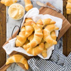 Square dish lined with white towel and filled with crescent rolls