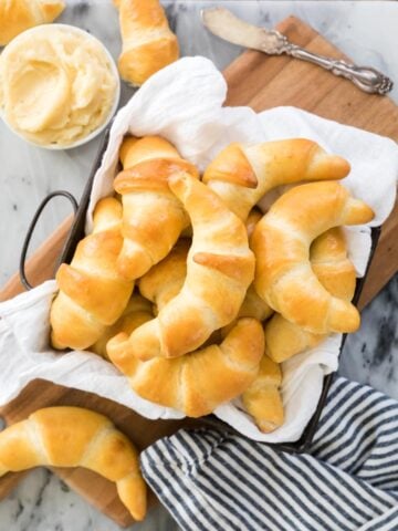 Square dish lined with white towel and filled with crescent rolls