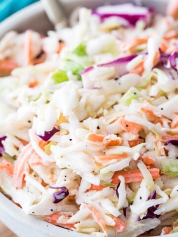 large bowl of homemade coleslaw full of shredded green and purple cabbage, carrots, and creamy dressing co