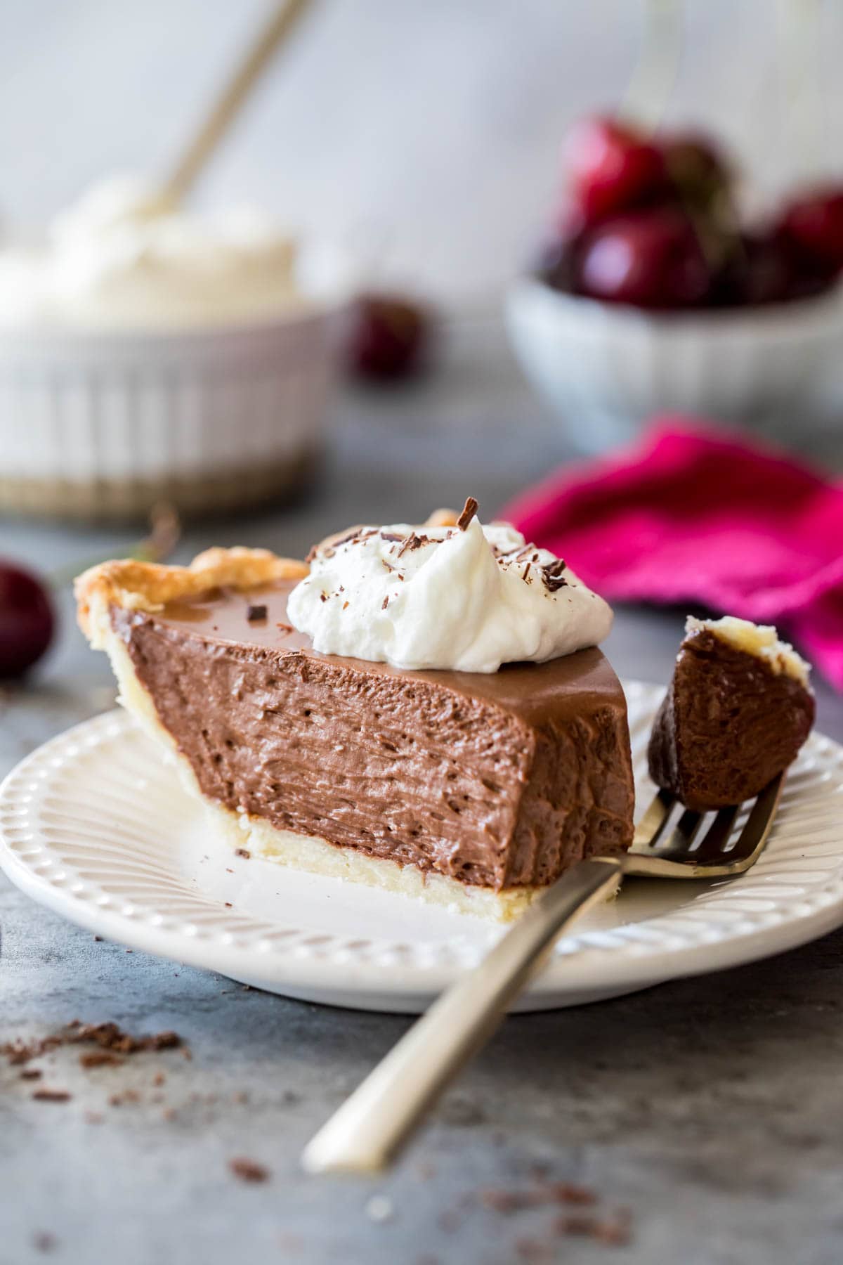 Slice of pie on a plate with a fork taking the first bite.