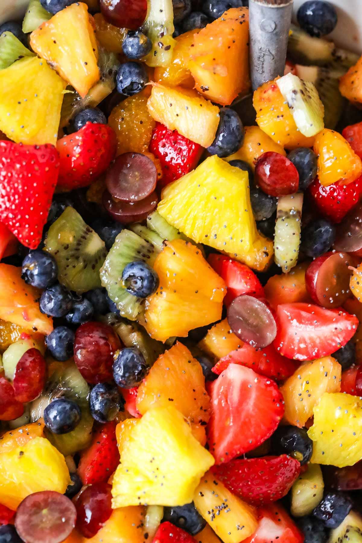 Close-up view of fruit salad made with pineapple, kiwi, berries, and oranges.