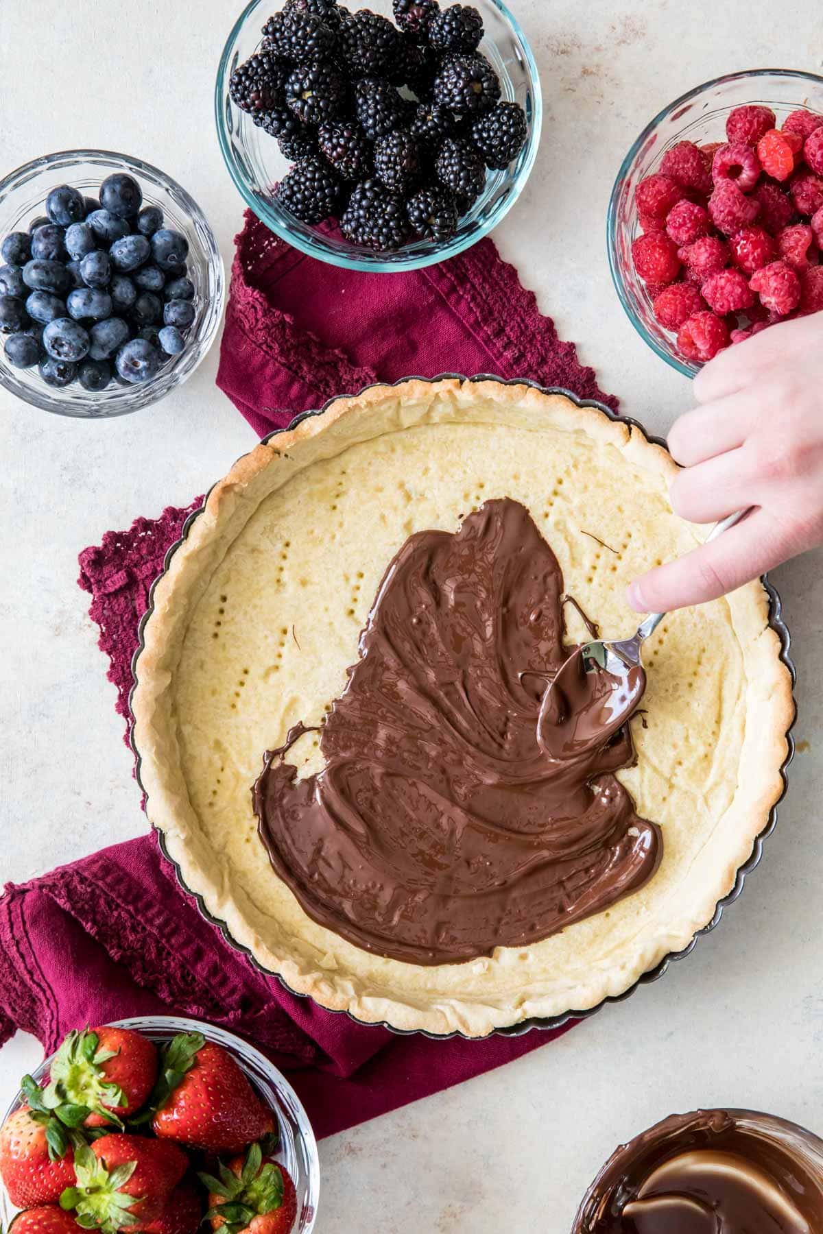 spreading chocolate over tart crust