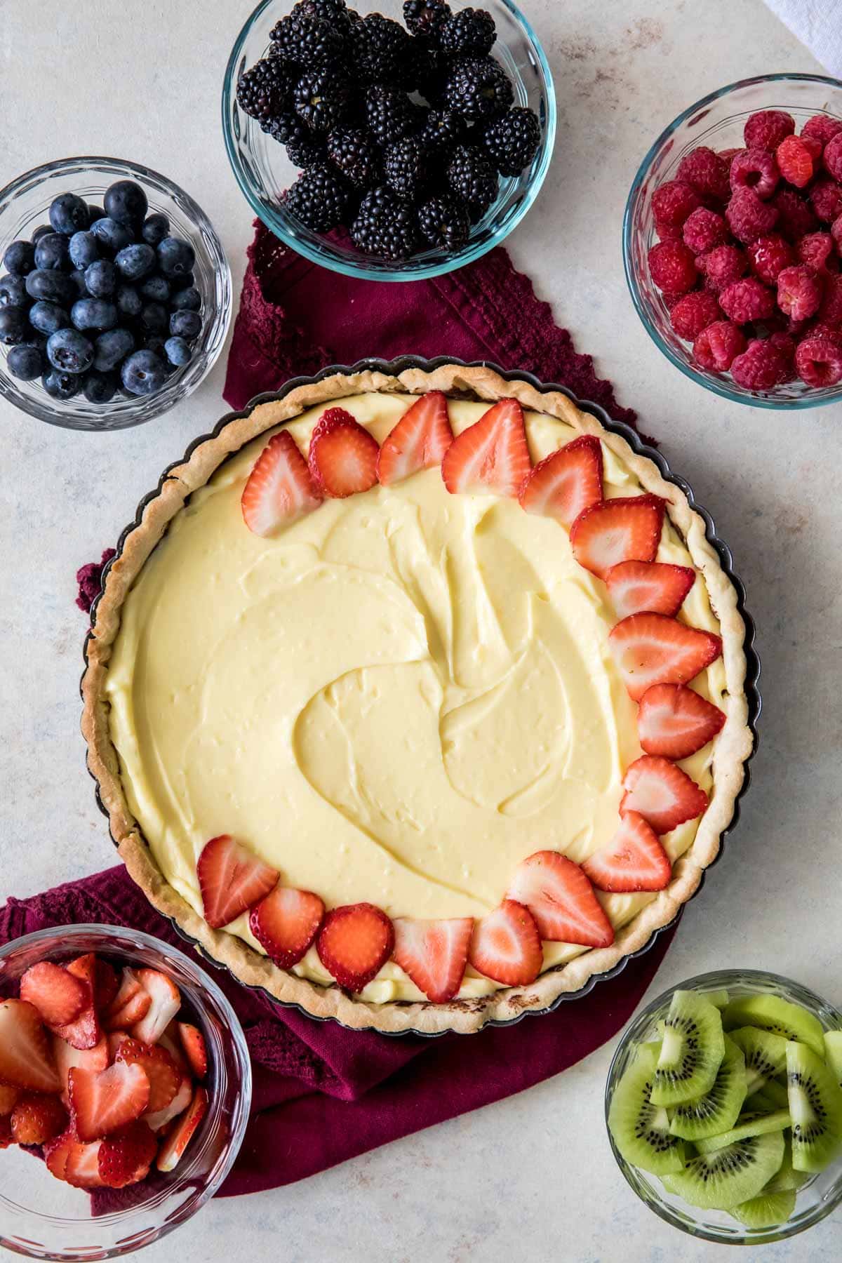 arranging strawberry slices over pastry cream