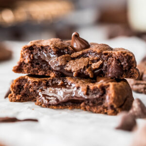 two halves of a chocolate fudge cookie stacked to show its soft, fudgy center