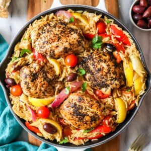 Overhead view of Greek chicken orzo in a cast iron skillet.