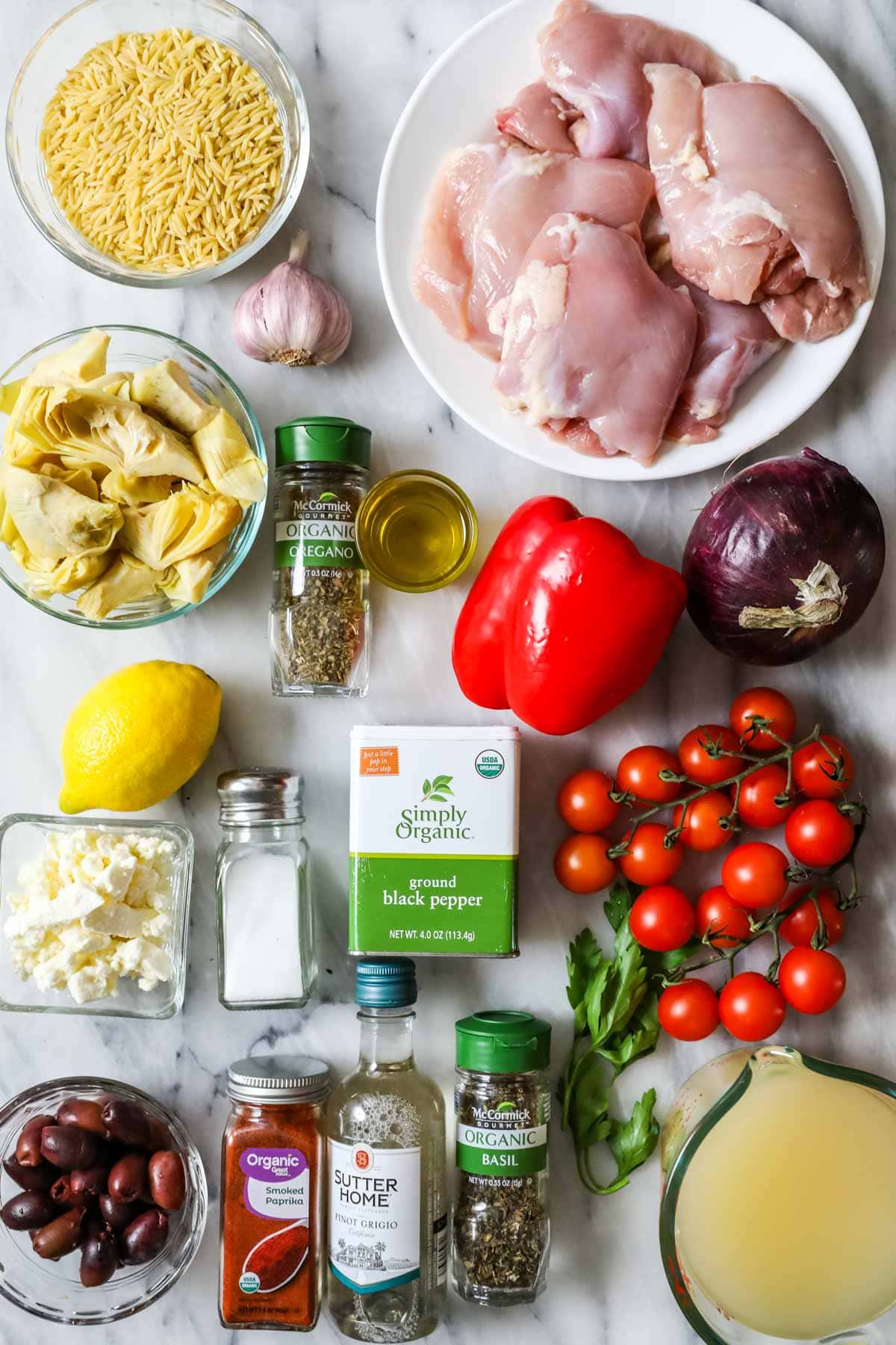 Overhead view of ingredients including chicken, orzo, tomatoes, and more.