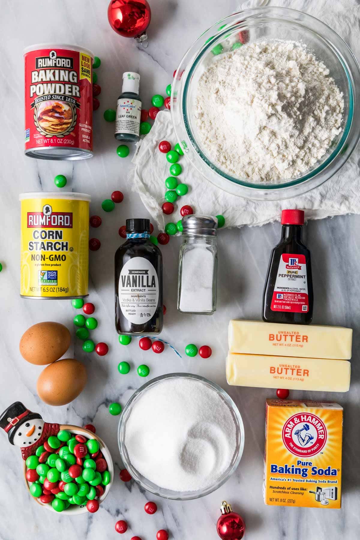 Overhead view of ingredients including m&m candies, peppermint extract, corn starch, food coloring, and more.