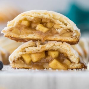 Apple hand pie cut in half and stacked on top of itself showcasing the flaky pastry dough and juicy apple filling.