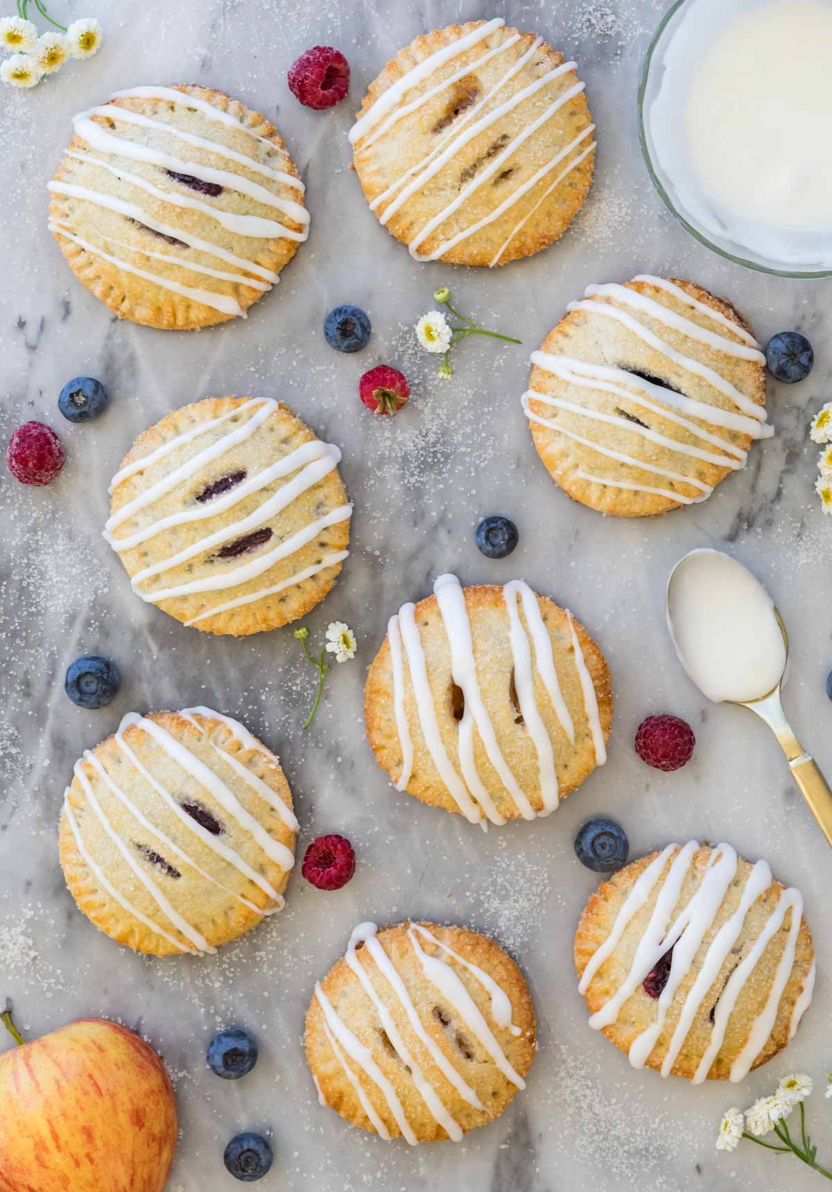 Overhead photograph of fruit-filled hand pies drizzled with vanilla glaze