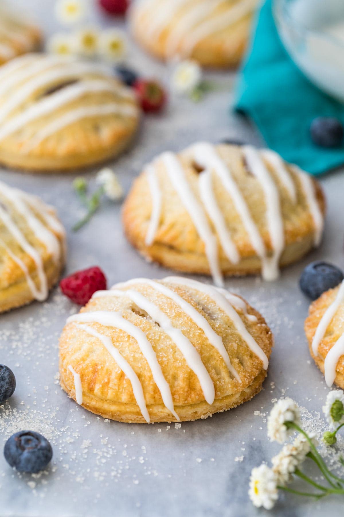 fruit-filled hand pies with vanilla glaze drizzle on marble