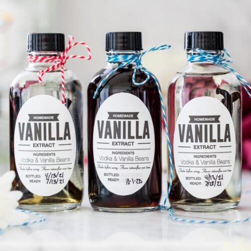 Three bottles of homemade vanilla extract with different color string on the tops