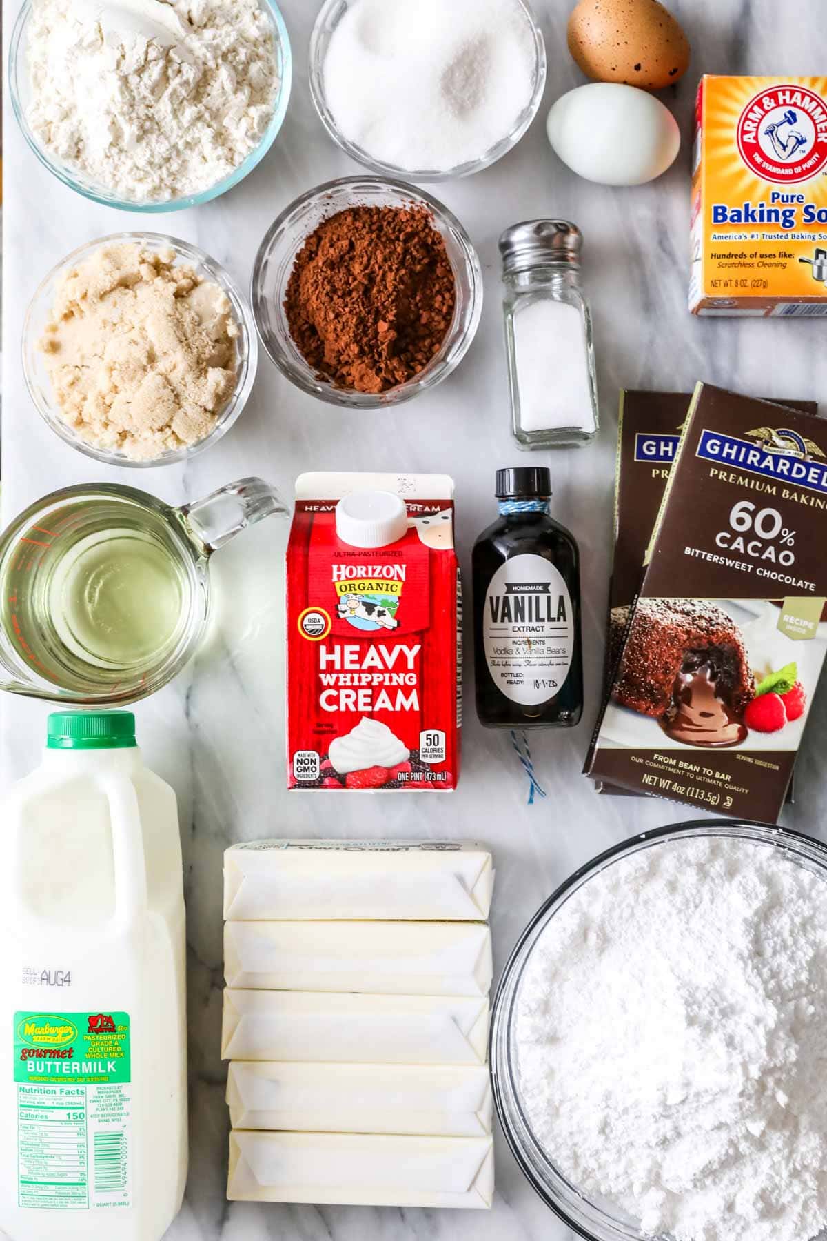 Overhead view of ingredients including chocolate bars, buttermilk, cocoa powder, and more.