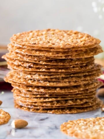 Lace cookies stacked on marble surface