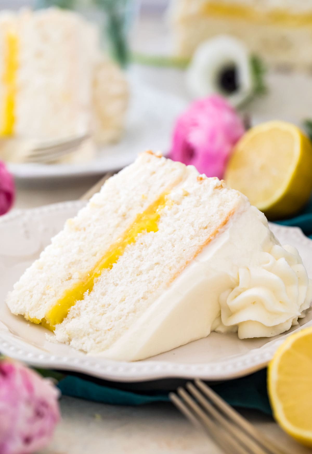 slice of homemade lemon cake filled with lemon curd and iced with a whipped cream cheese frosting
