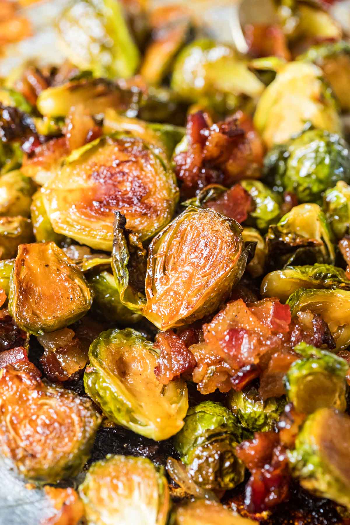 Crispy roasted brussels sprouts made with bacon and maple syrup on a baking sheet.