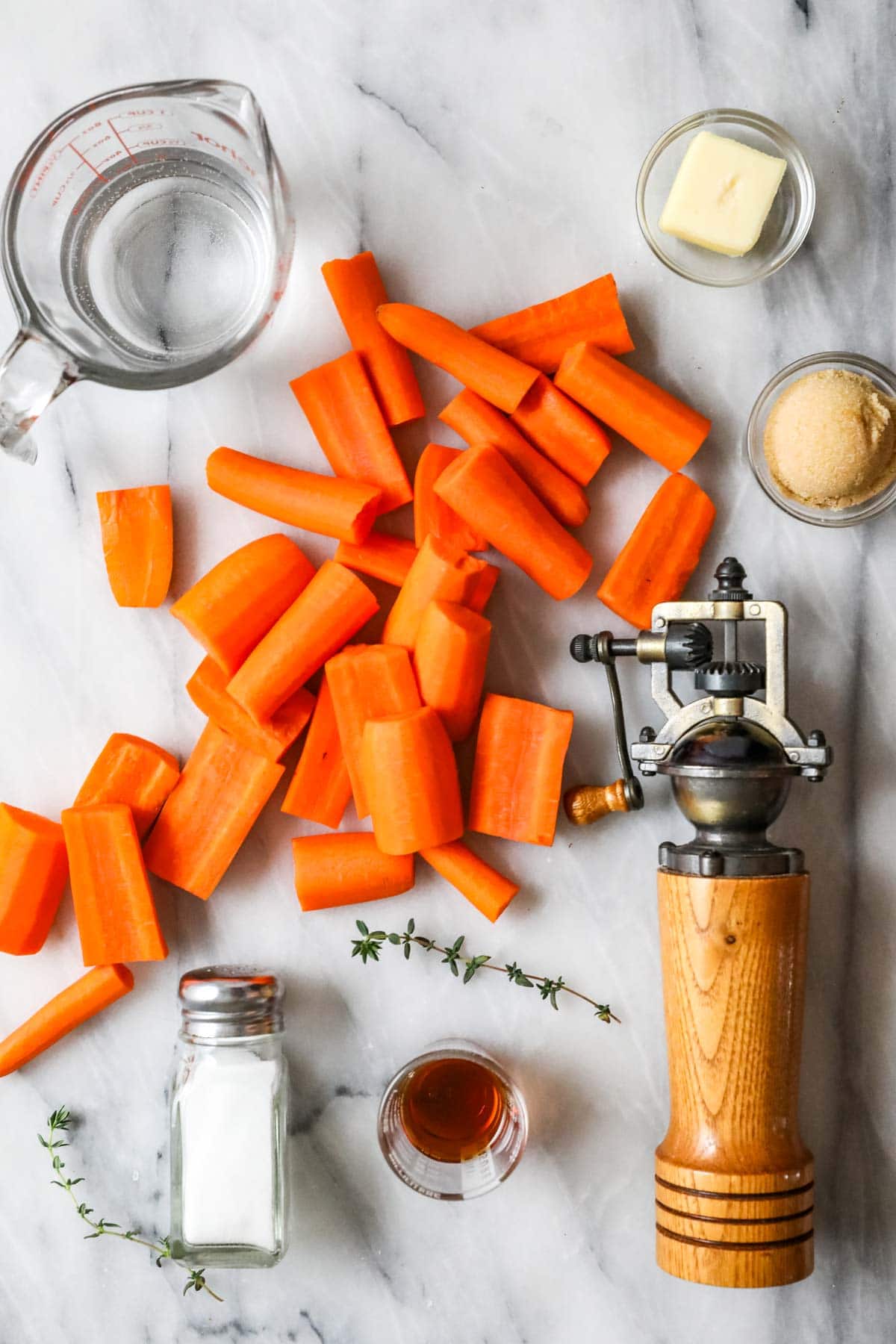 Overhead view of ingredients including carrots, maple syrup, butter, and more.