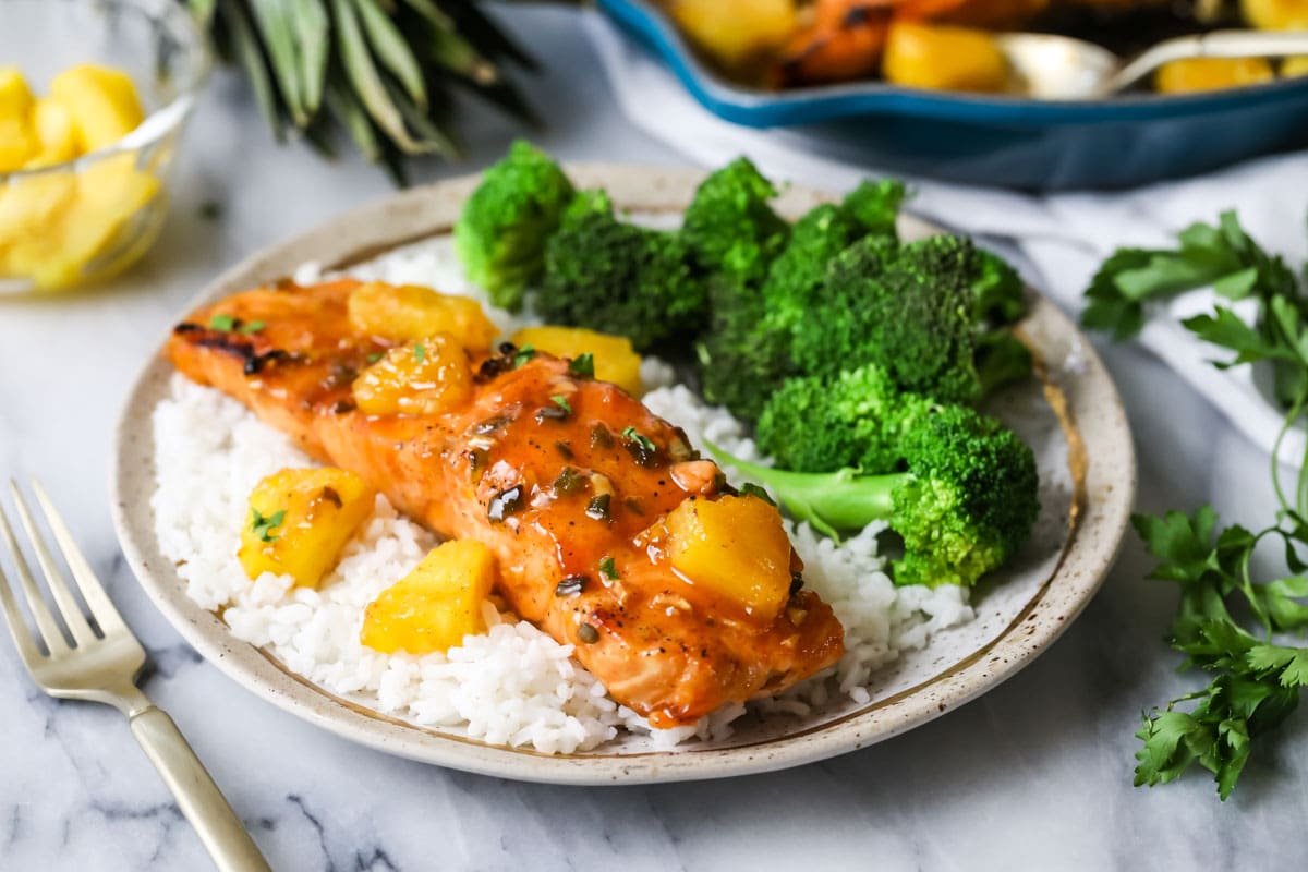 Filet of maple glazed salmon served on a bed of rice with a side of broccoli.