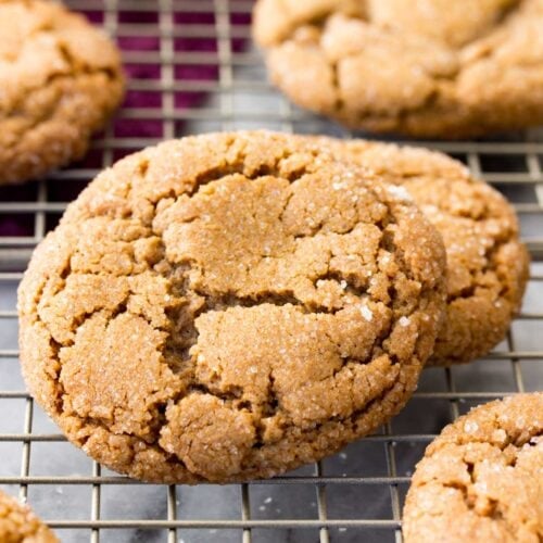 Crackly topped molasses cookies on a cooling rack after baking.