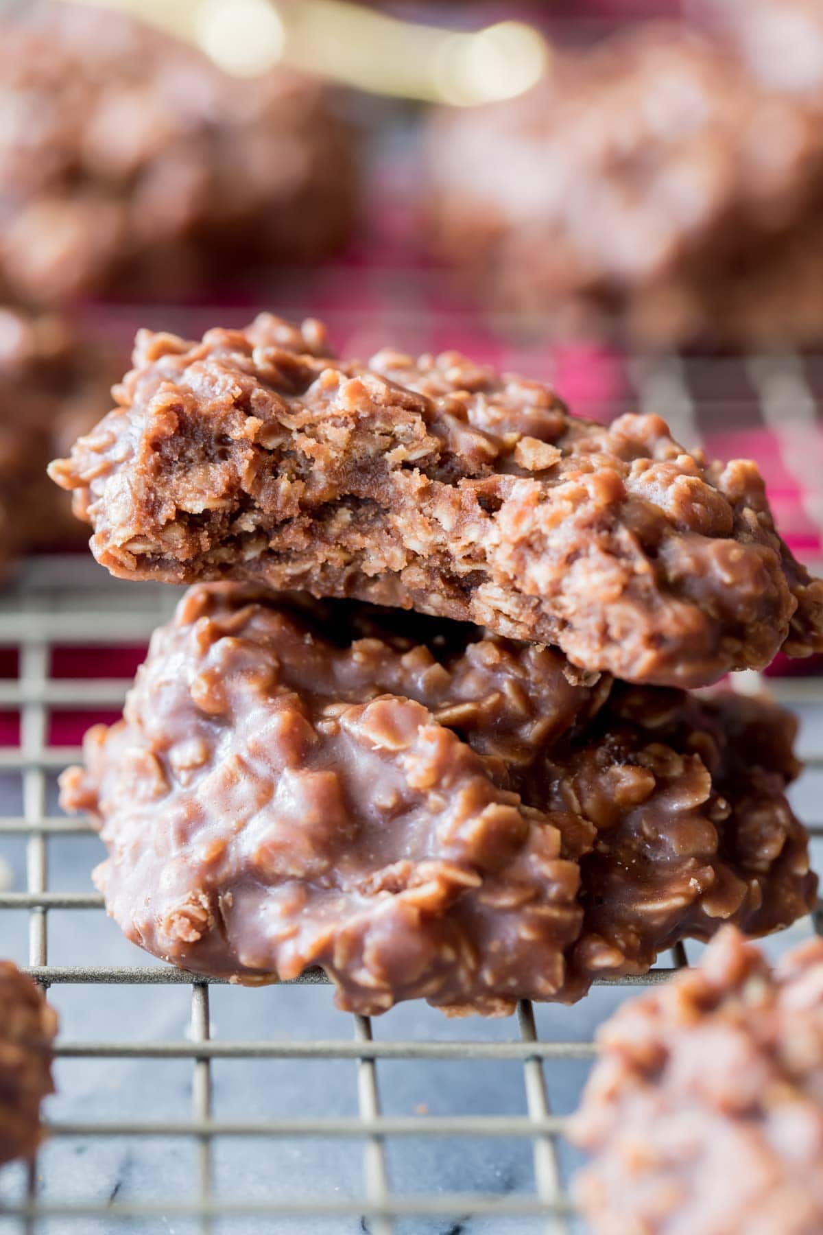 two no-bake cookies stacked on top of each other on a metal cooling rack, with the top cookie missing a bite