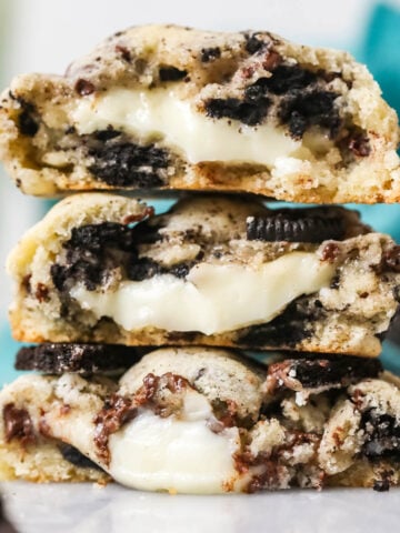 Three Oreo cheesecake cookies cut in half and stacked on top of each other.