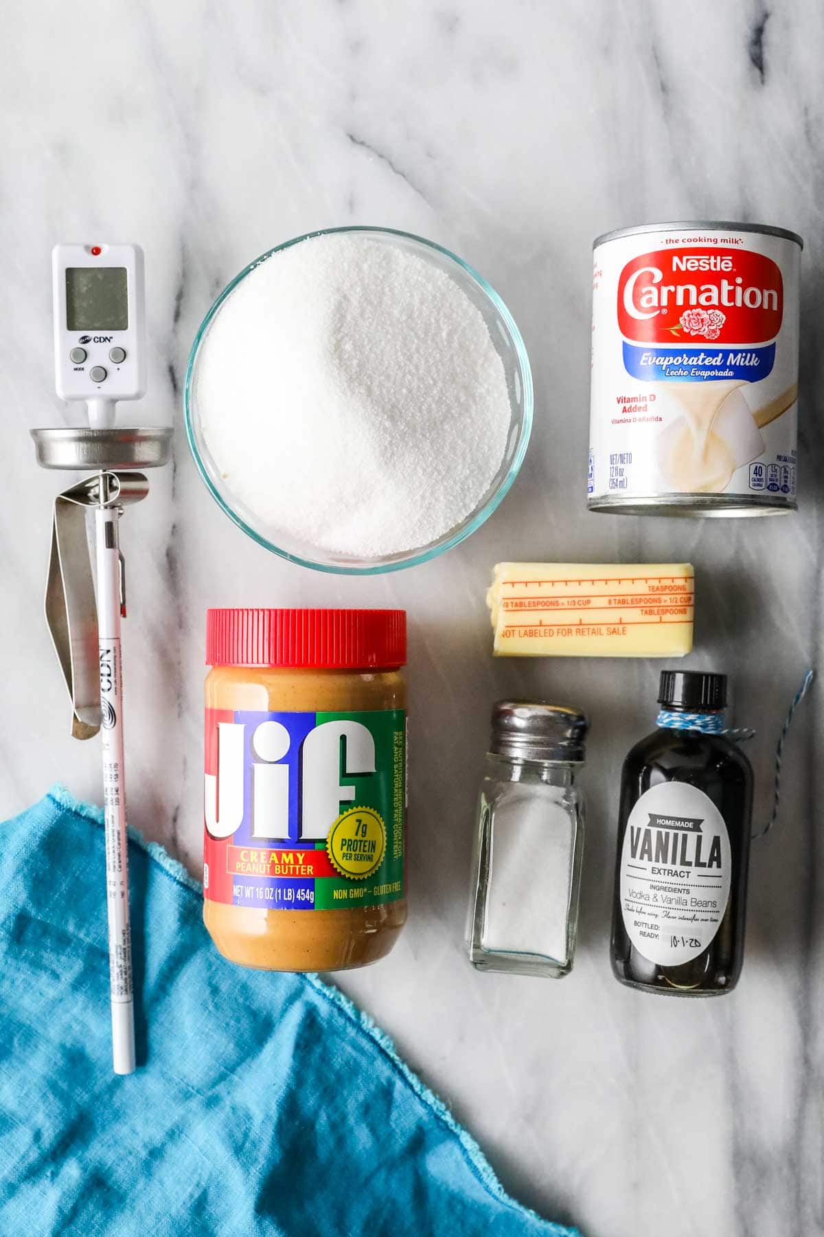 Overhead view of ingredients including peanut butter, sugar, evaporated milk, salt, vanilla, and butter.