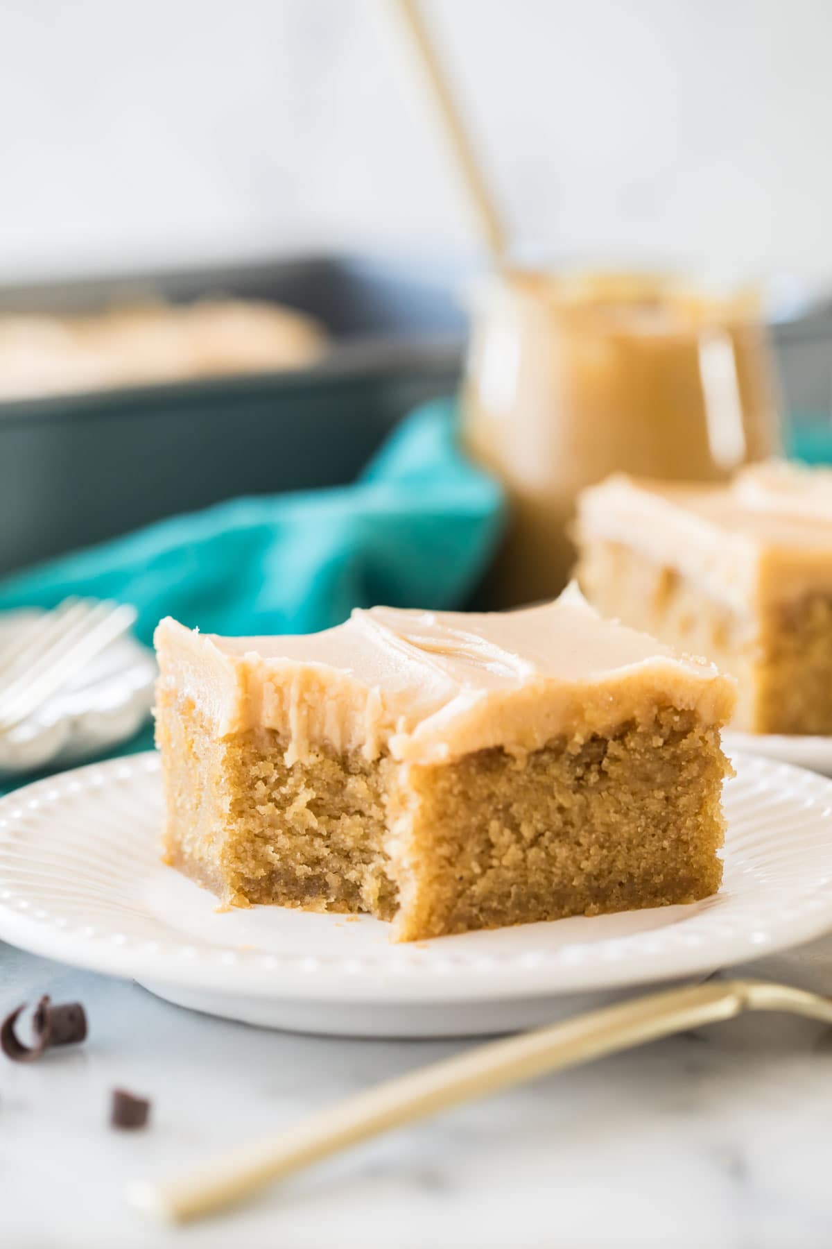 Bite missing from a slice of sheet cake frosted with peanut butter frosting.