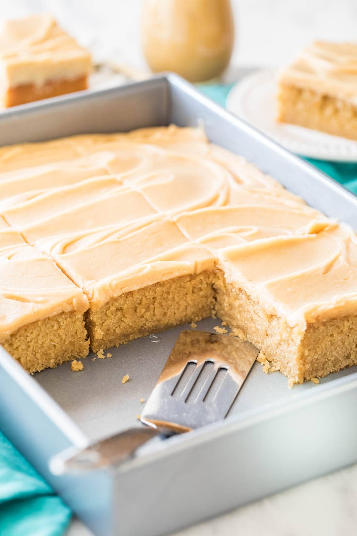 Peanut butter sheet cake that's been frosted and sliced in its pan.