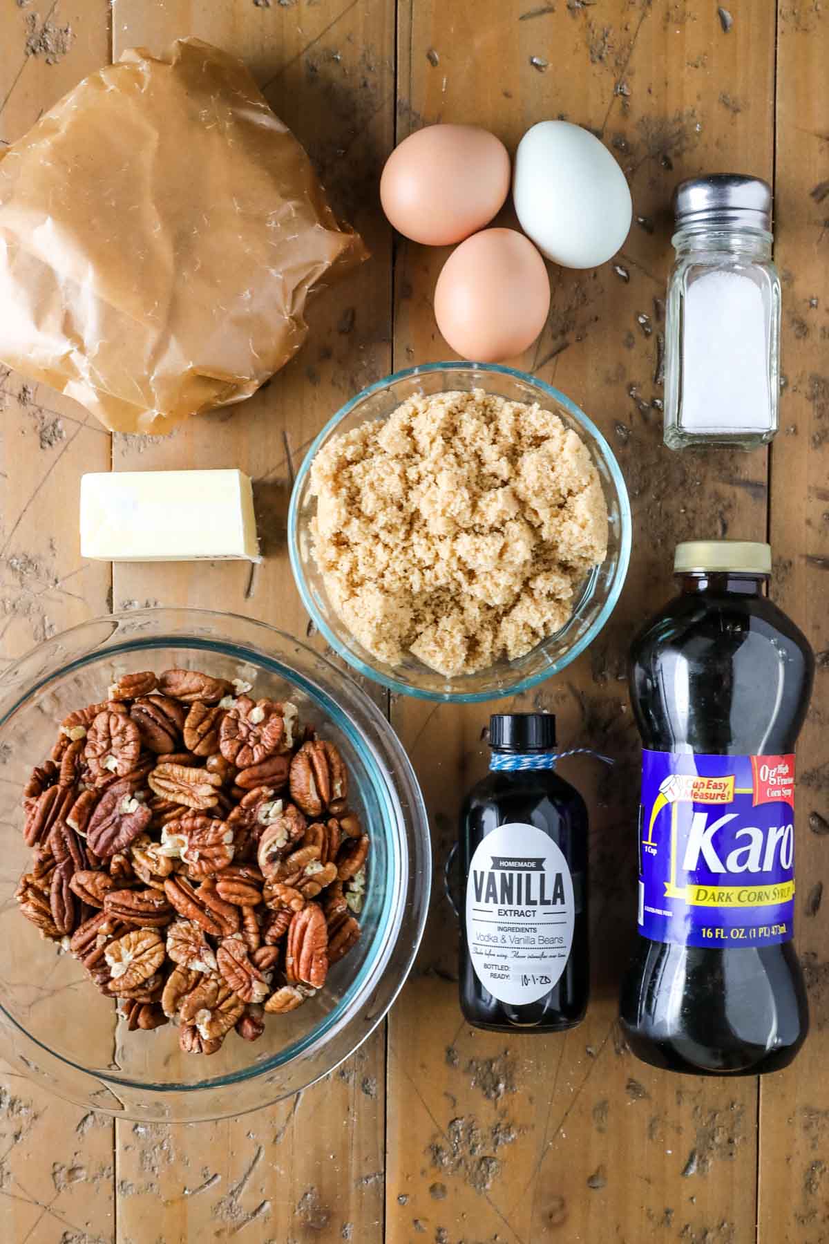 Overhead view of ingredients including pecans, pie dough, brown sugar, dark corn syrup, and more.