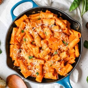 Overhead view of pink sauce pasta in a blue cast iron skillet.