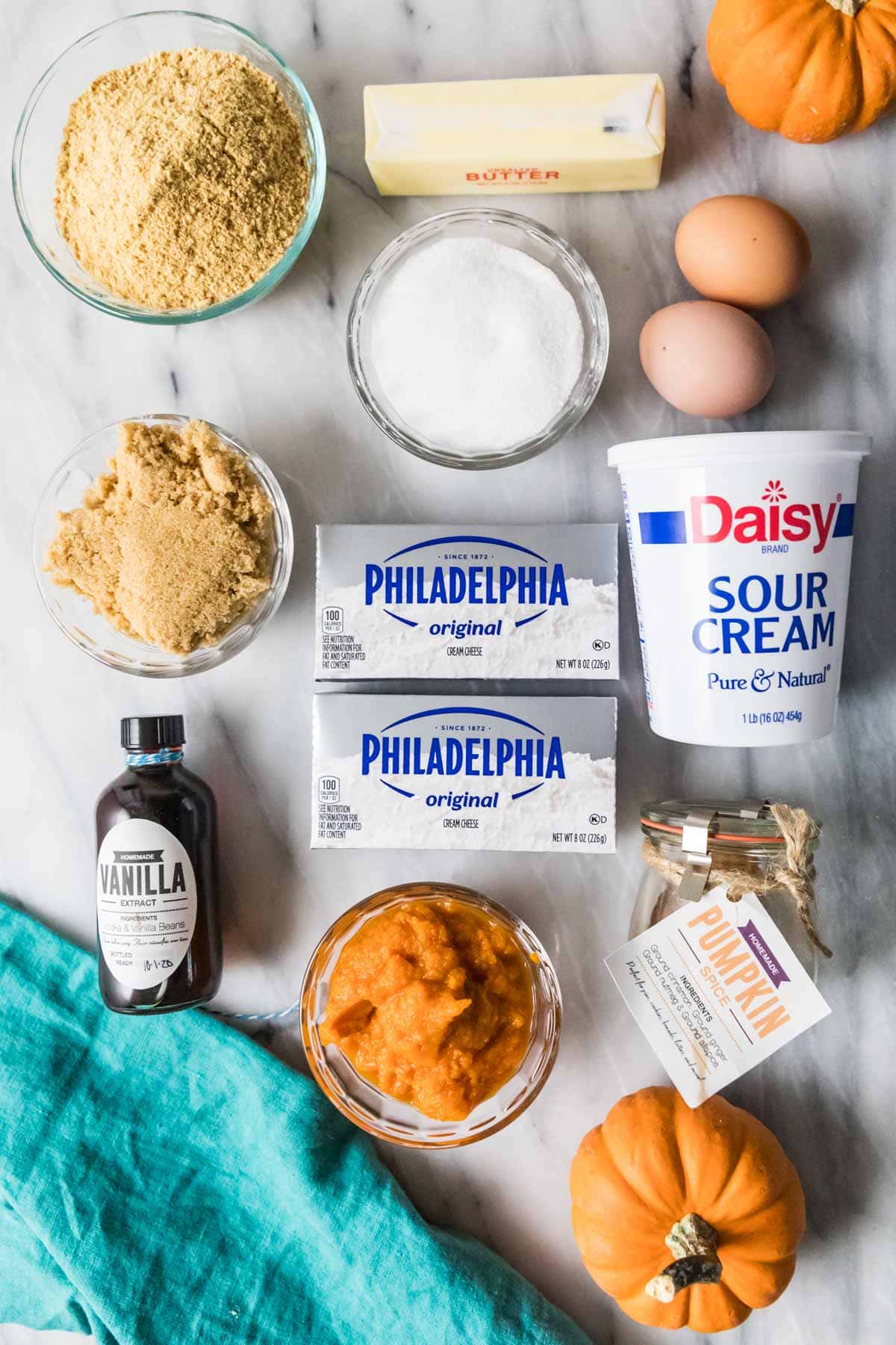 Overhead view of ingredients including cream cheese, pumpkin puree, sour cream, and more.